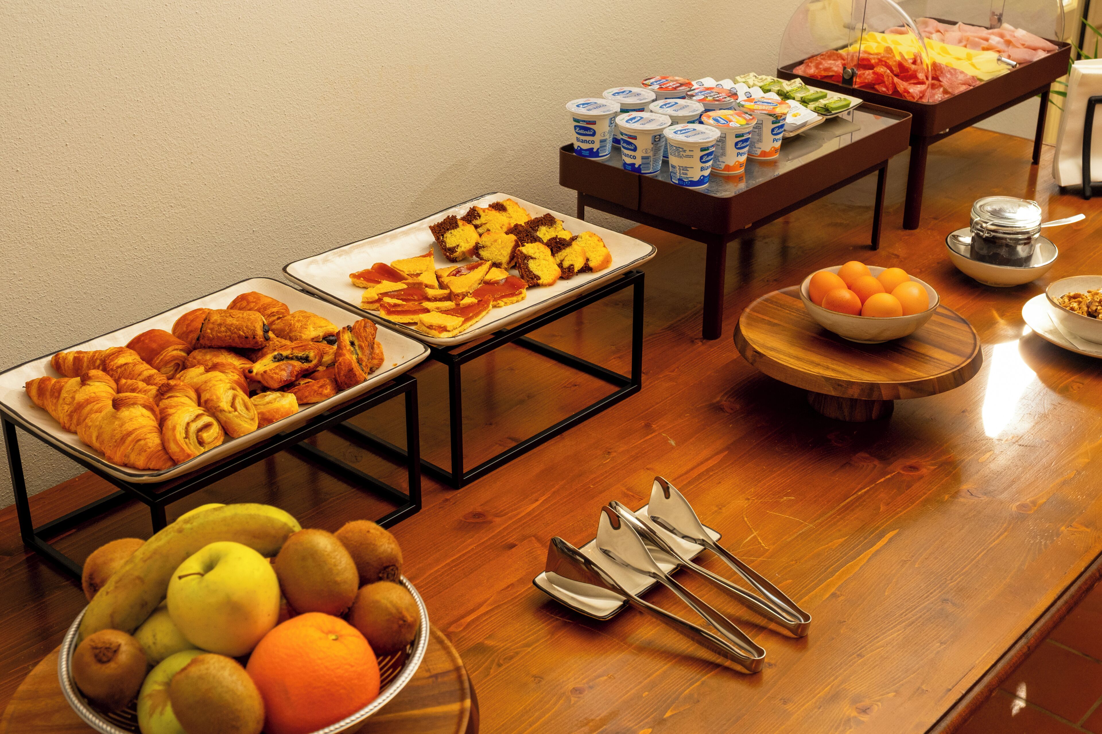 Ein Buffet mit verschiedenen Speisen, darunter Obst, Gebäck und Milchprodukte.