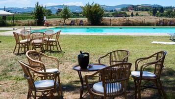 En säsongsöppen utomhuspool och solstolar