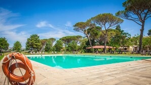 A swimming pool with a lifebuoy, surrounded by trees and outdoor furniture. - Tenuta la Fratta (Sinalunga)