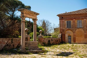 Una antigua estructura de piedra con columnas y un edificio con ventanas de arco.