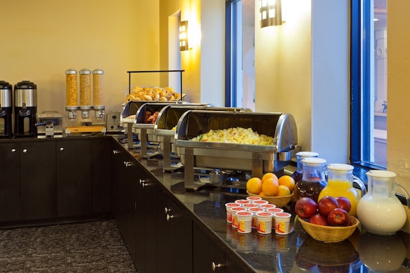 A buffet with various food items and beverages, including cereal, fruits, and juices. - Best Western Plus New Orleans Airport Hotel (Kenner)