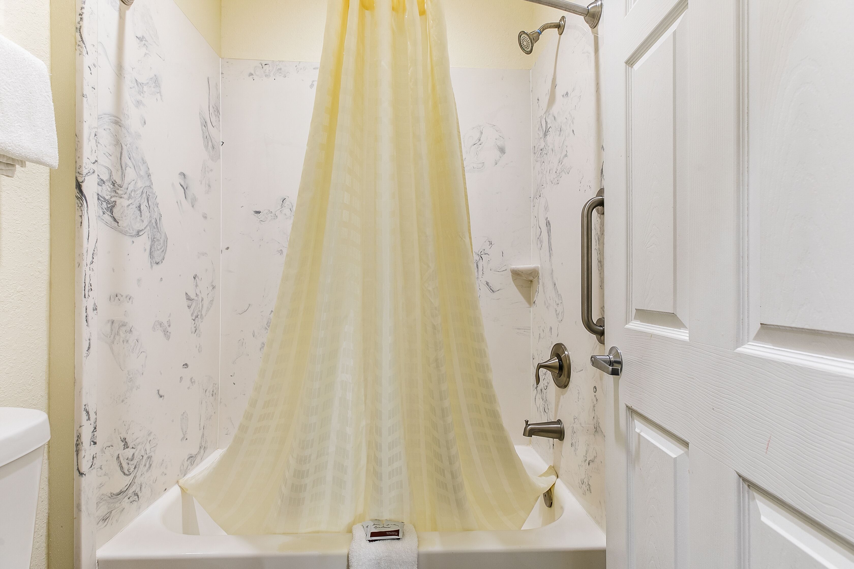Un baño con bañera, cortina de ducha y retrete.