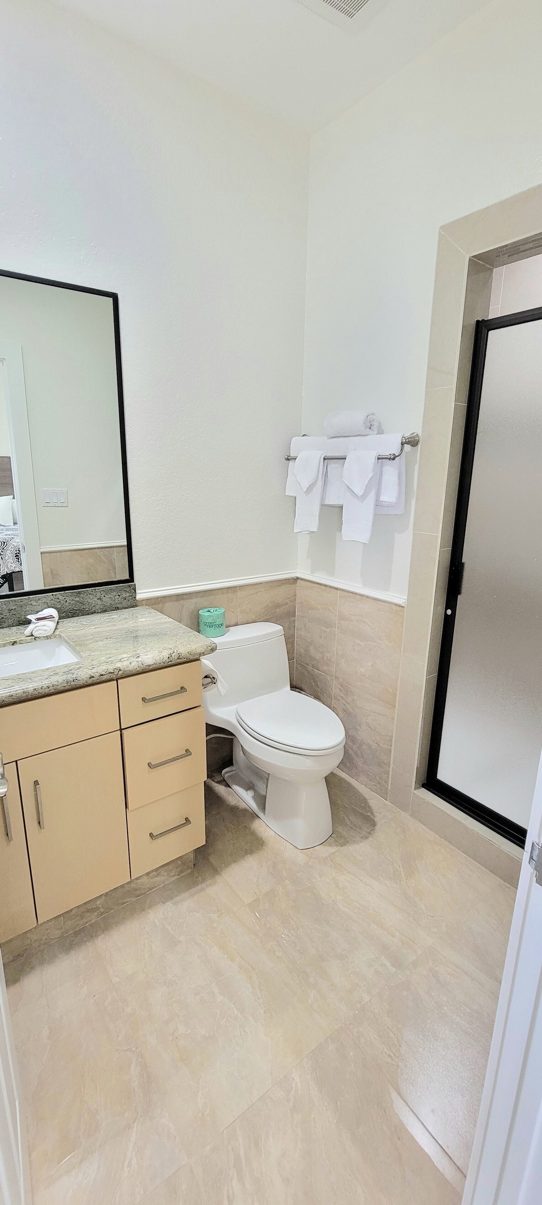A bathroom with a sink, toilet, and towel rack.