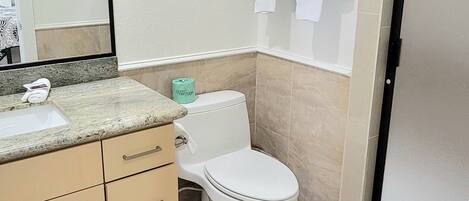 A bathroom with a sink, toilet, and towel rack.