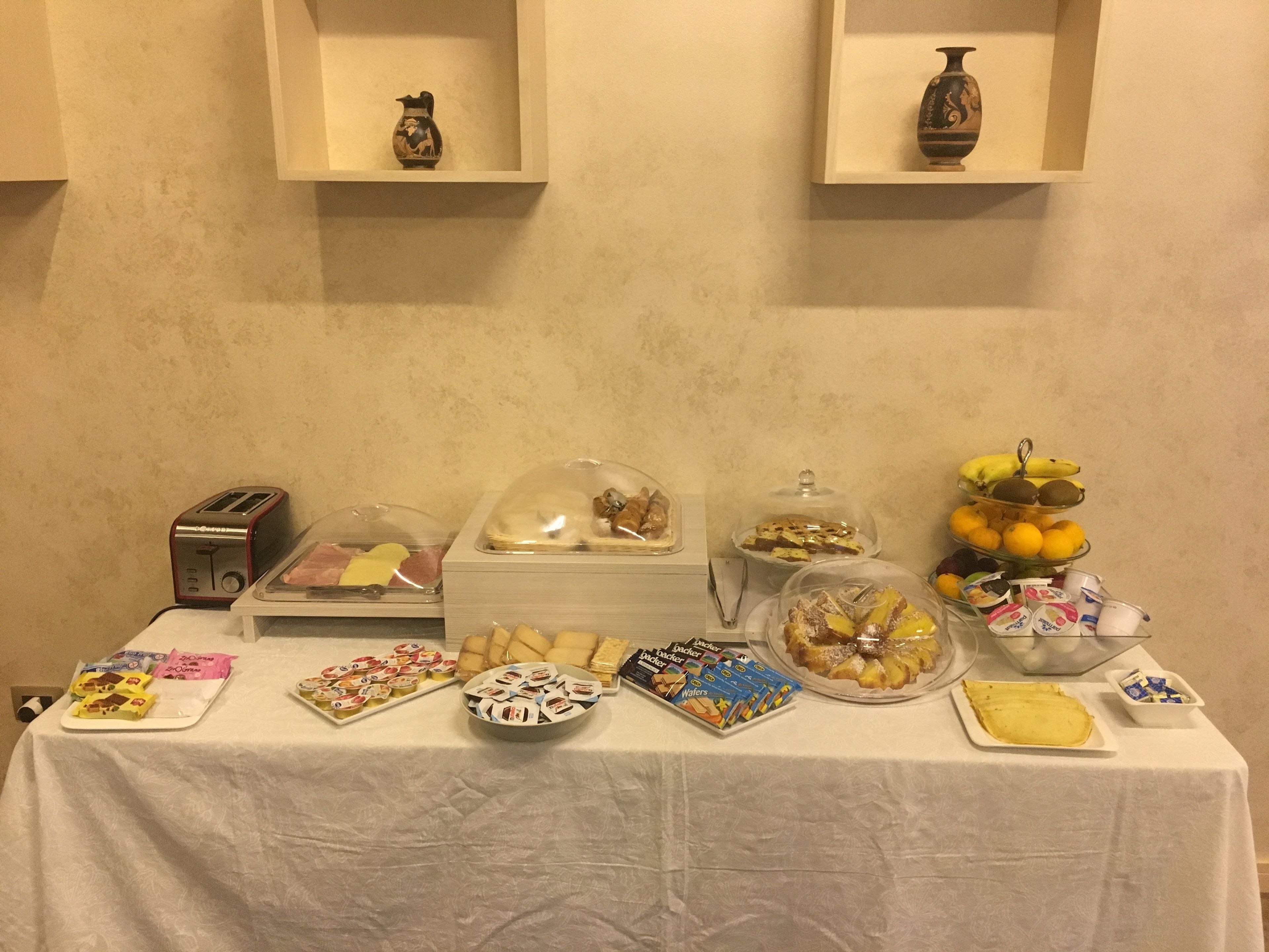 Una mesa de buffet con diversos alimentos y un tostador.