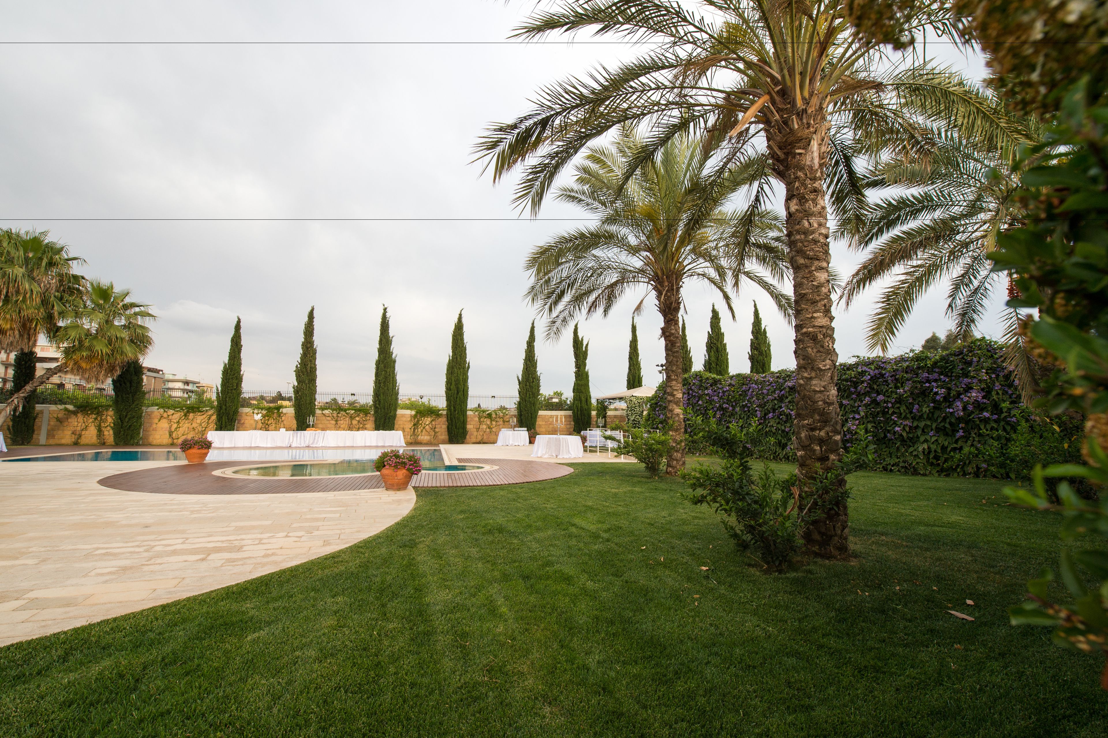 A landscaped outdoor area with a pool, palm trees, and a circular seating area.