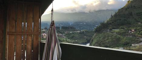 A room with a view of a valley and mountains.