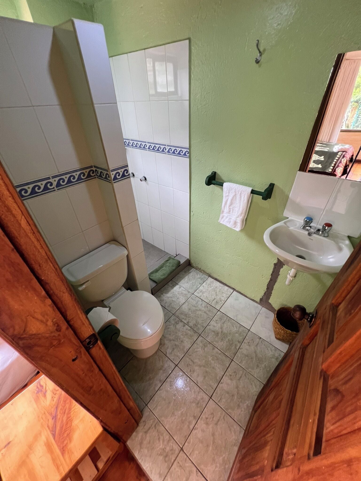 A small bathroom with a toilet, sink, and shower.