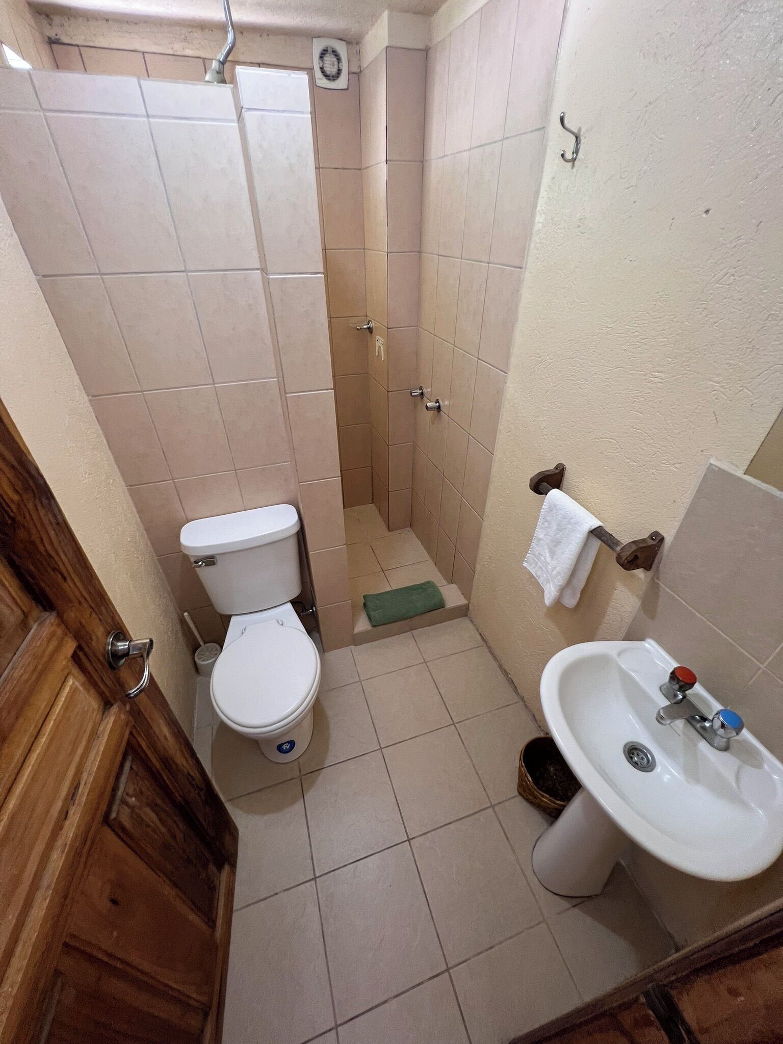 Une petite salle de bain comprenant des toilettes, un lavabo et une cabine de douche.