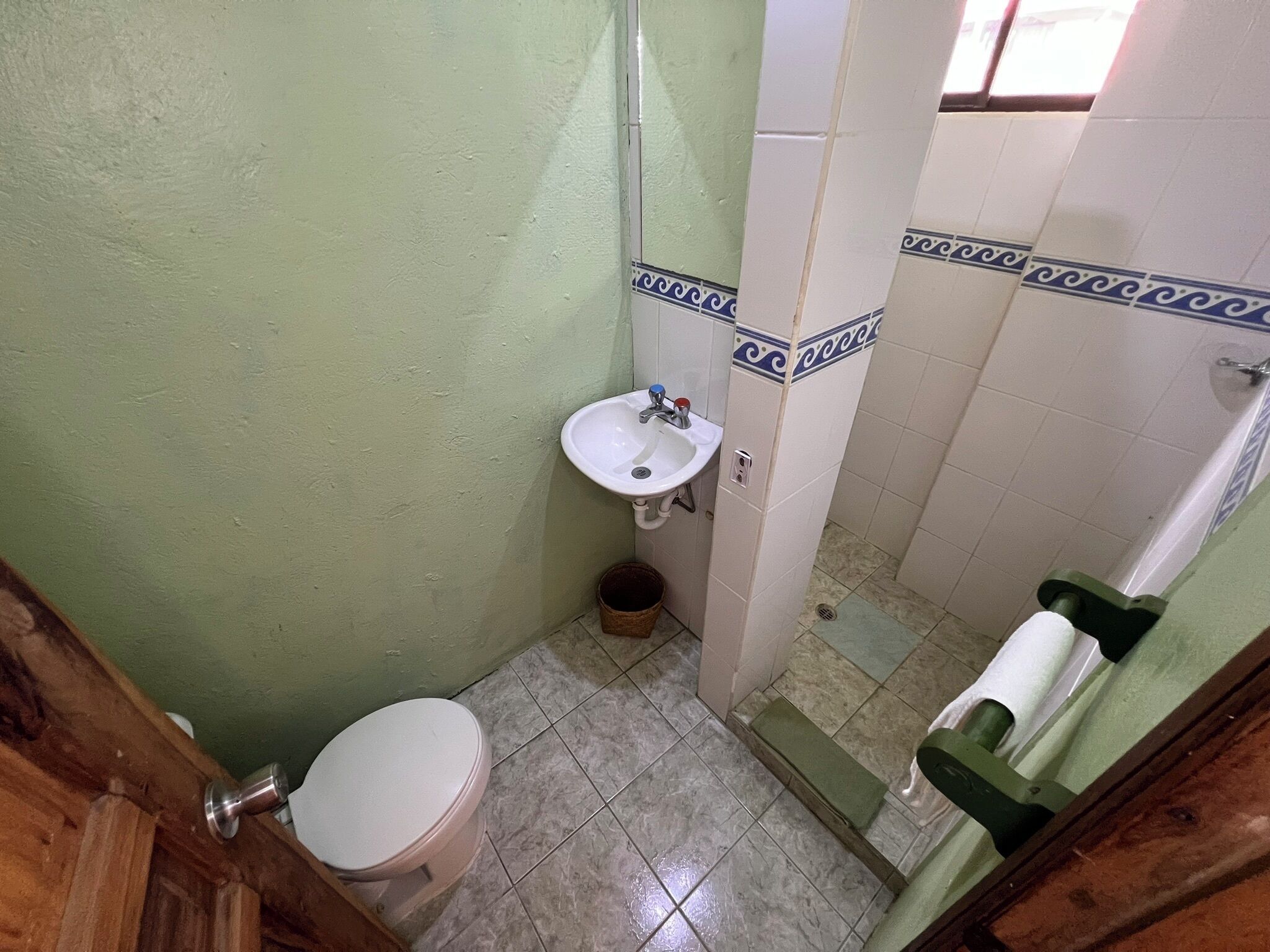 Une petite salle de bain avec des toilettes, un lavabo et une douche.