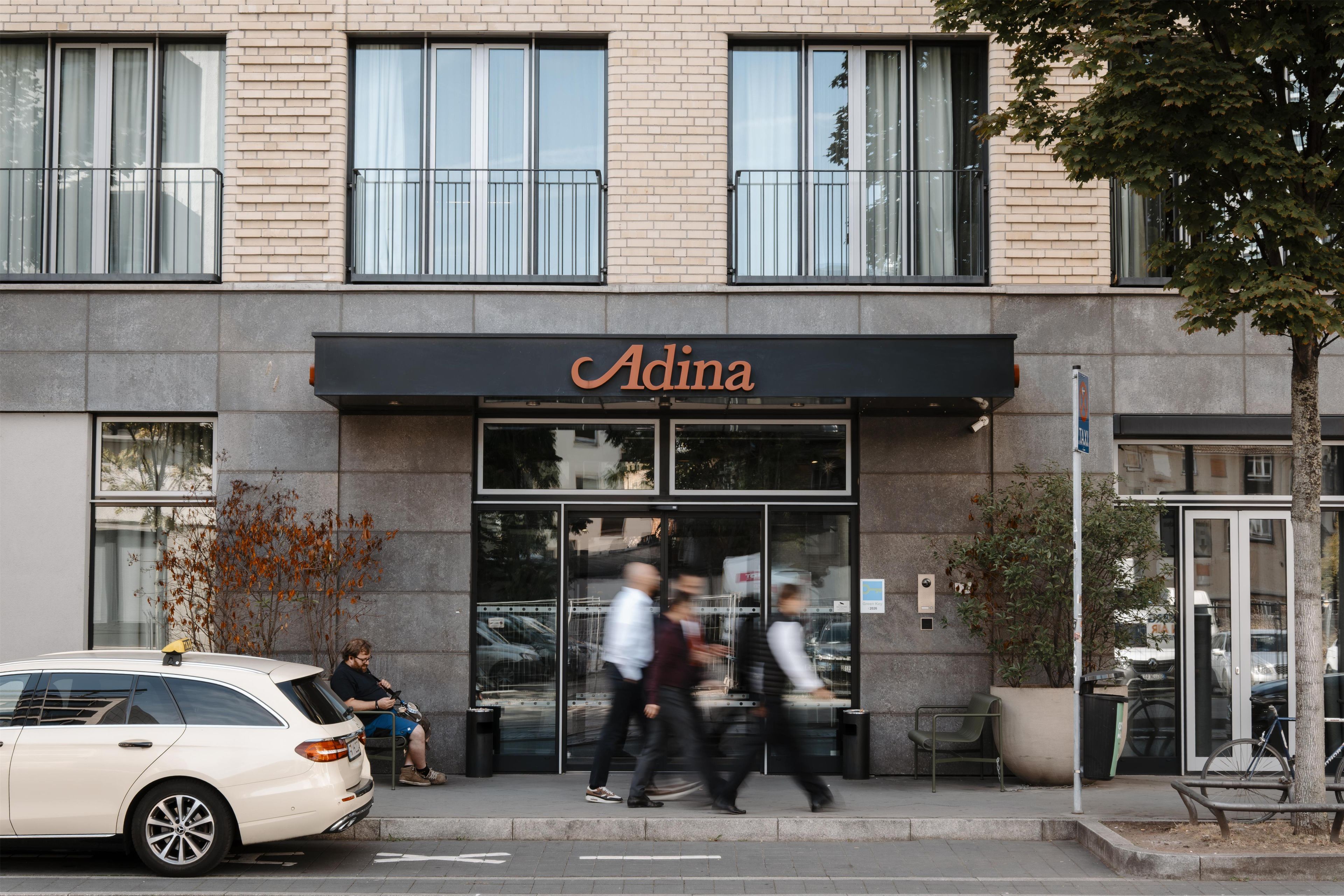 Un edificio con una fachada que dice 'Adina'.