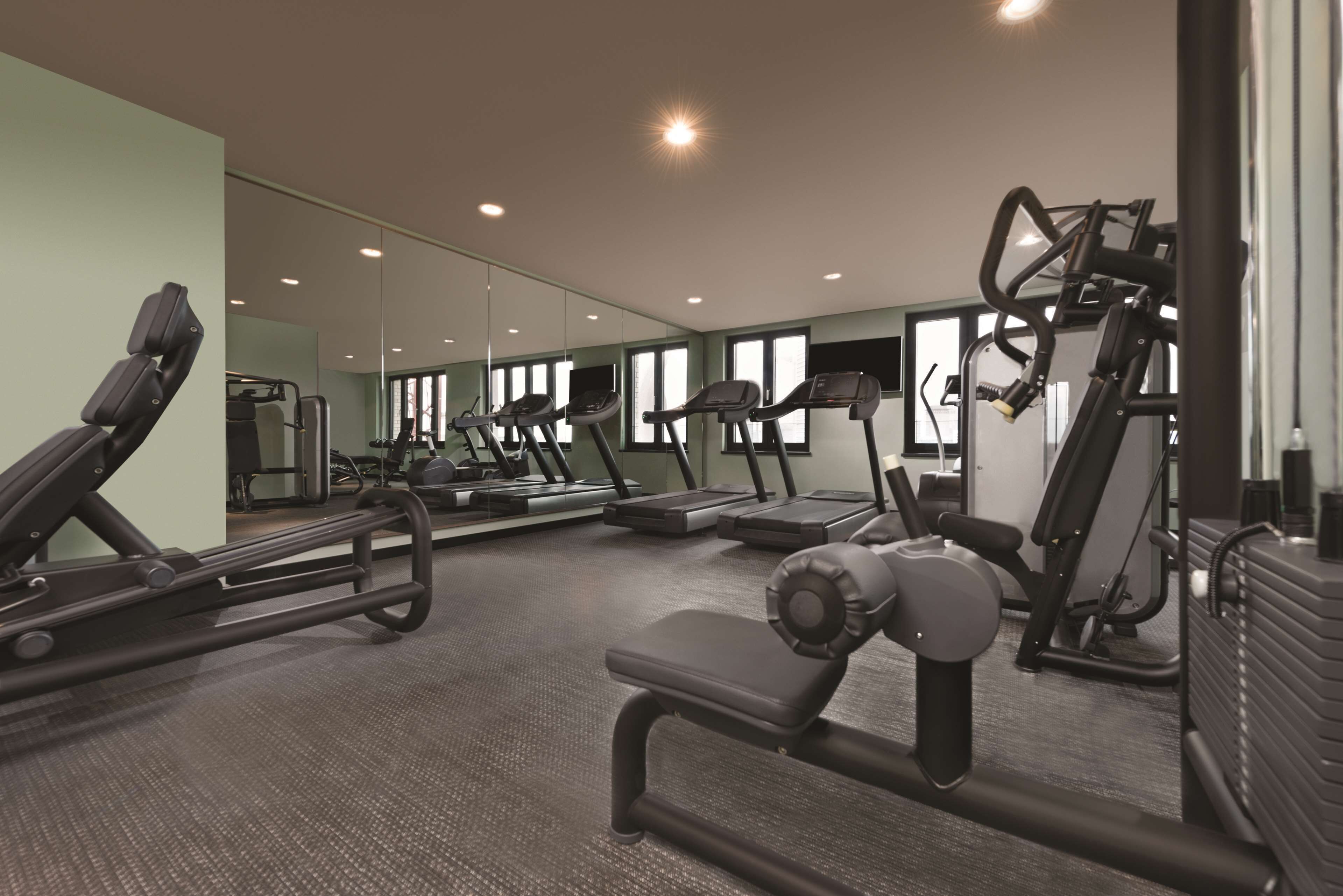 A gym with treadmills, elliptical machines, and weight equipment.