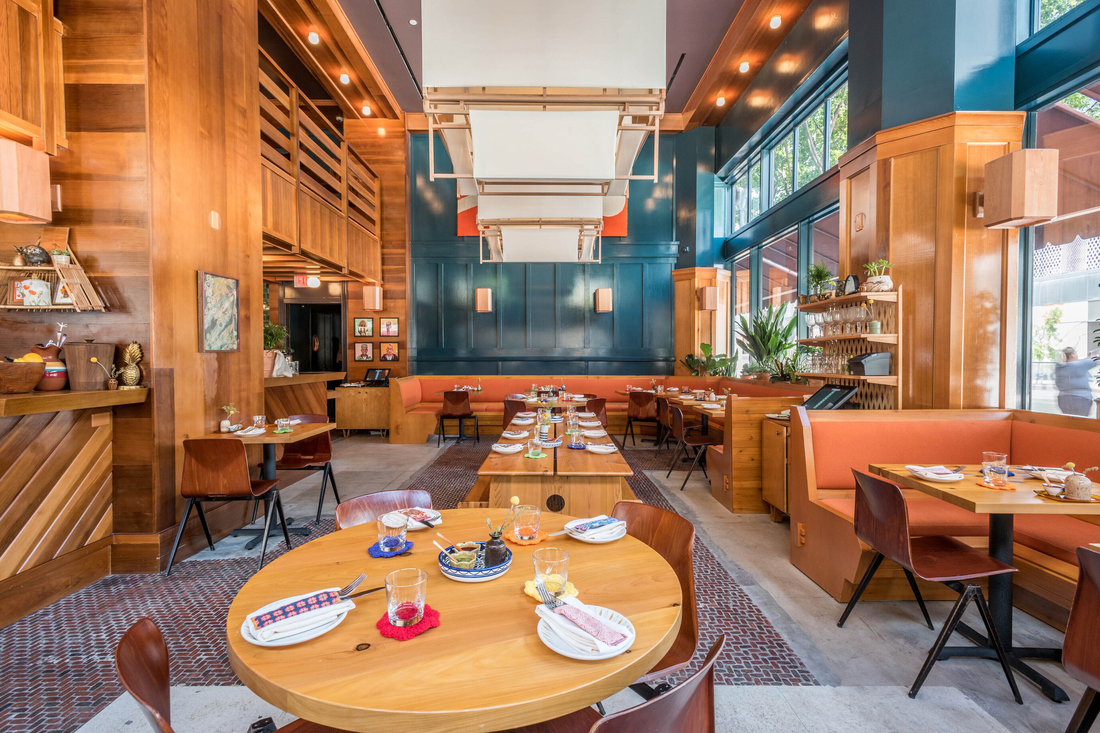 A restaurant with wooden decor, multiple dining tables, and booths.