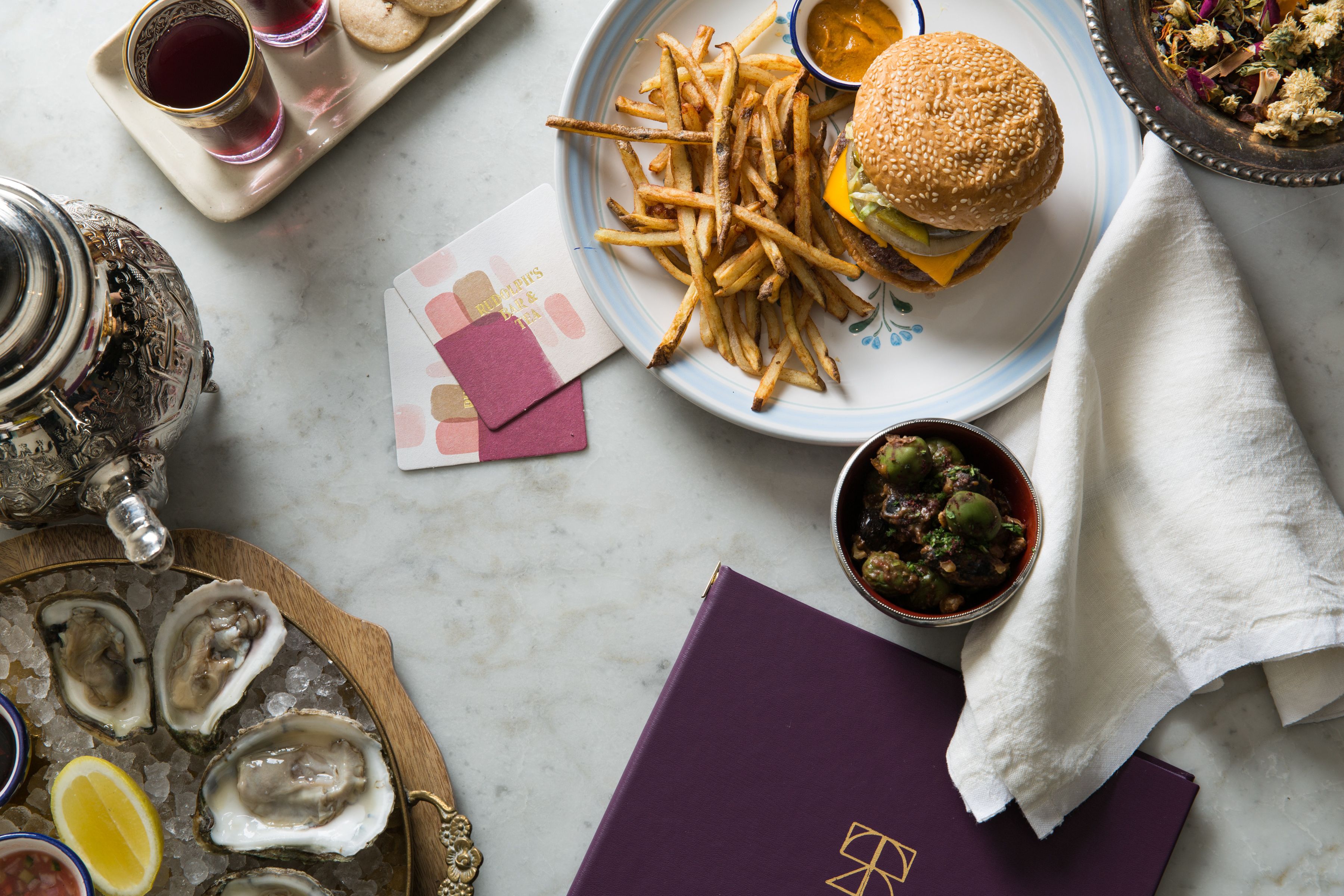 A dining table with a plate of food, a drink, and a menu.