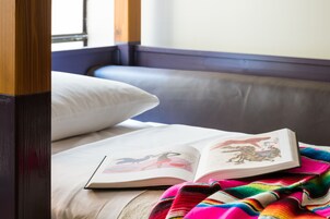 Un libro abierto sobre una cama con una manta colorida.