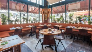 A spacious cafe with large windows, outdoor seating, and a variety of tables and chairs. - Freehand Los Angeles (Los Angeles)