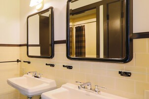 Un bagno con due lavandini, specchi e portasciugamani.