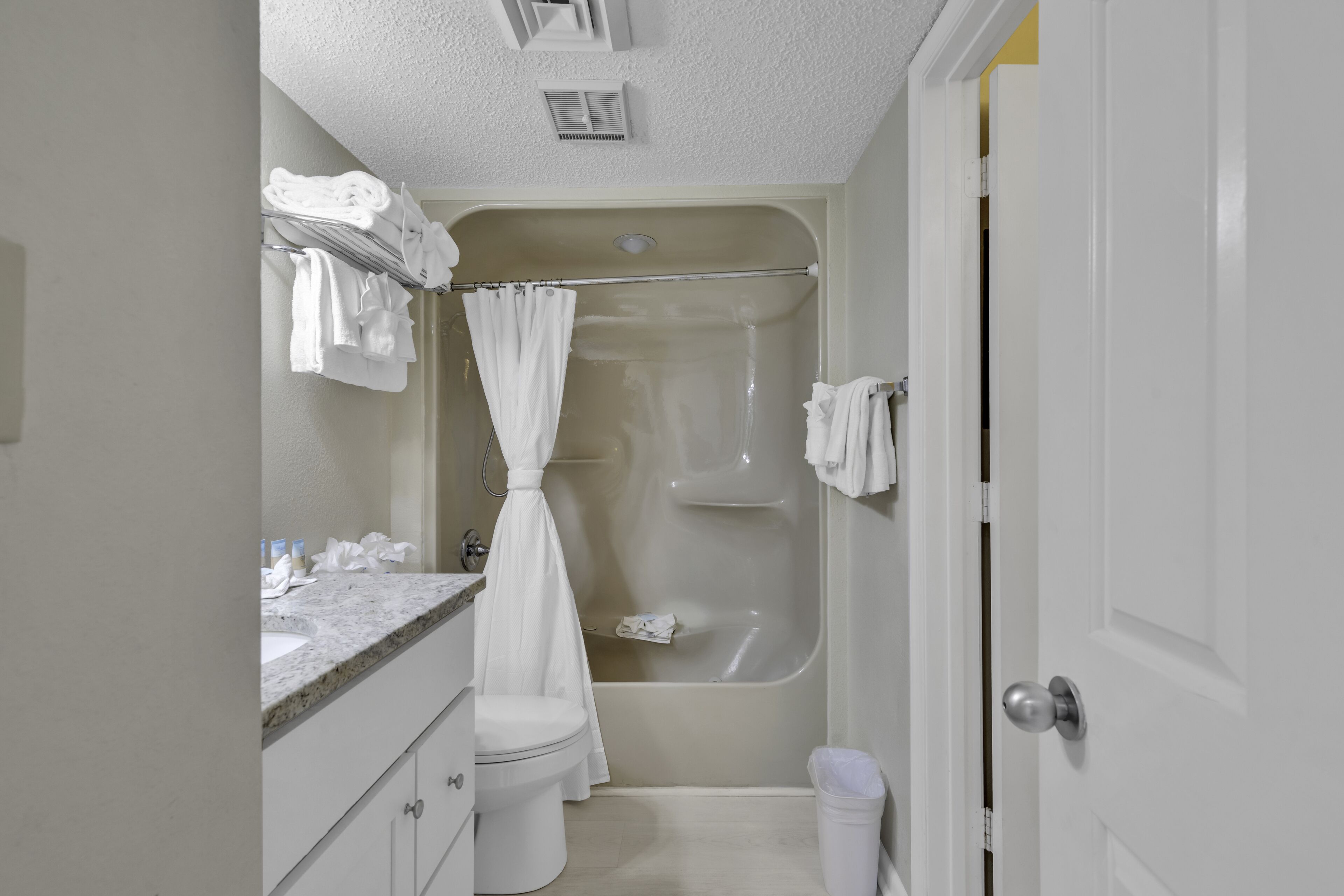 Une salle de bain équipée d’une baignoire, de toilettes, d’un lavabo et d’un rideau de douche.