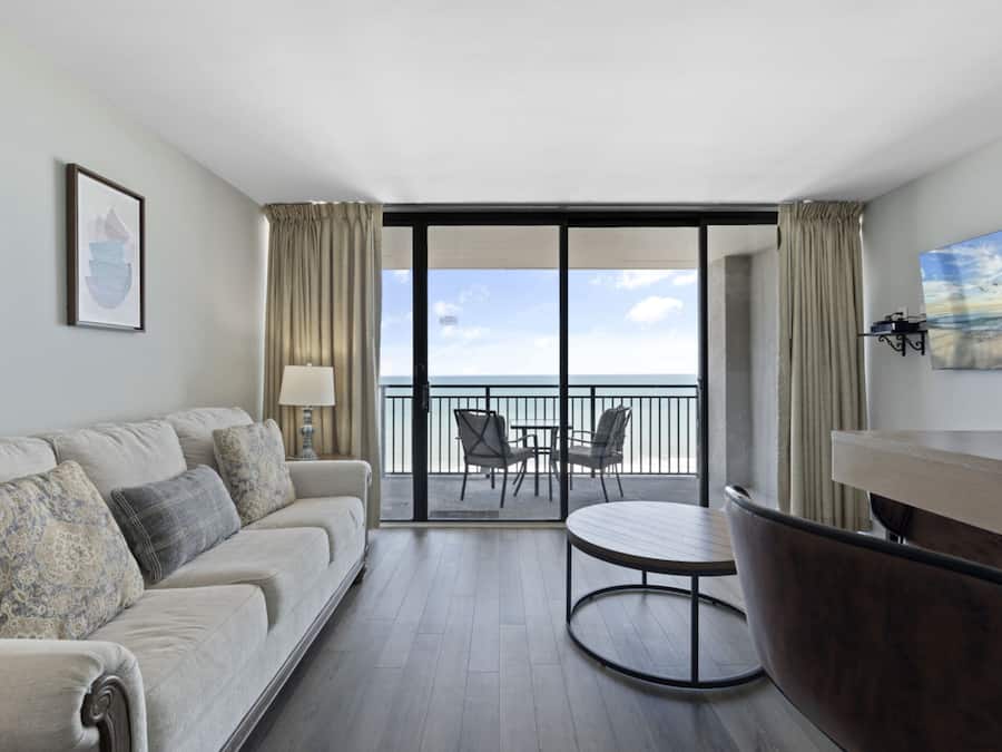 Condo com design assinado, 1 quarto, sacada, ao lado da praia | Sala de estar | TV de tela plana 42 polegadas com canais a cabo, TV