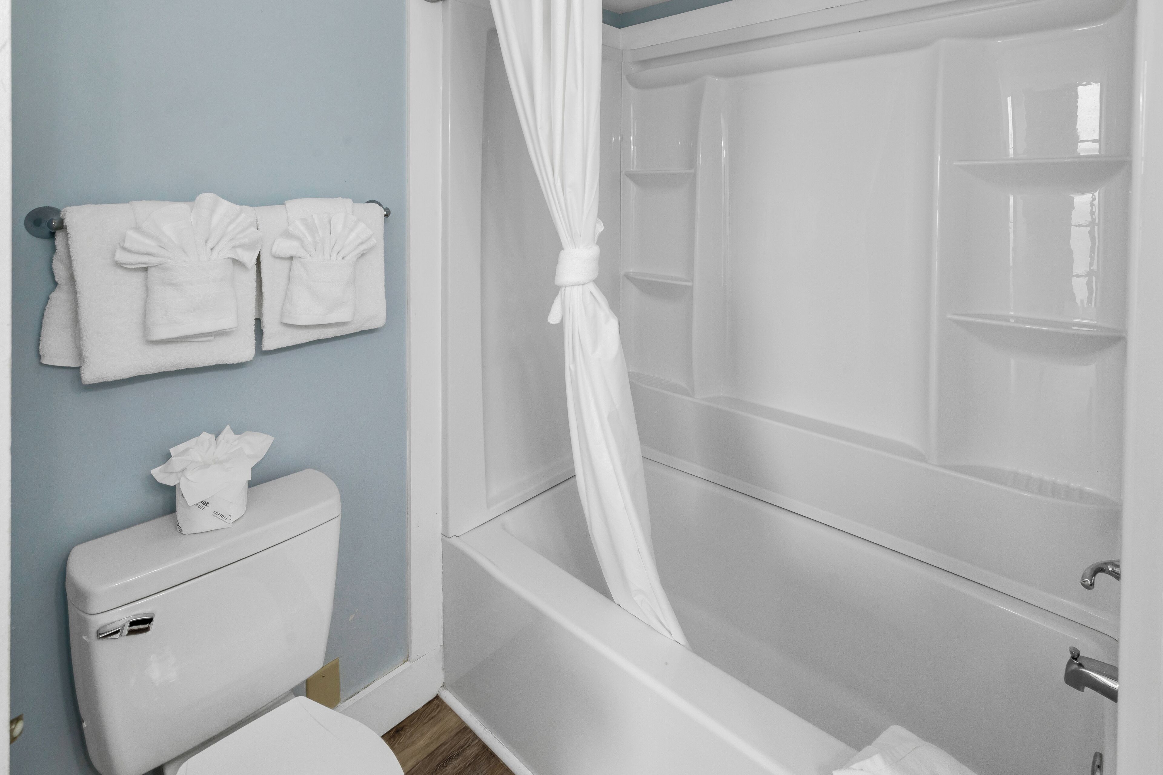 A bathroom with a bathtub, toilet, and towel rack.