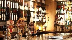 A bar with multiple beer taps and a variety of bottles in the background. - The Cross Keys (Saffron Walden)
