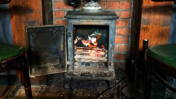 A fireplace with a brick wall and a metal plaque reading "COALBROOKDALE".