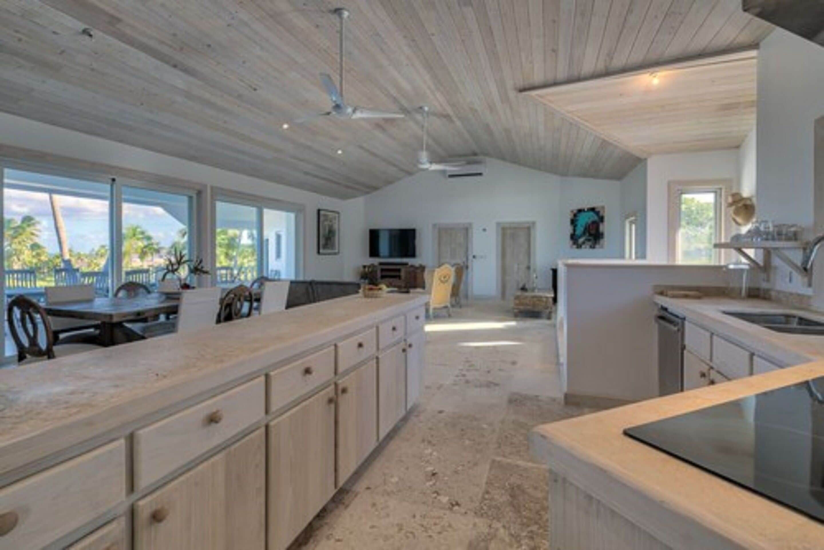 Una cocina amplia con una isla grande, techo de madera y vistas al exterior.