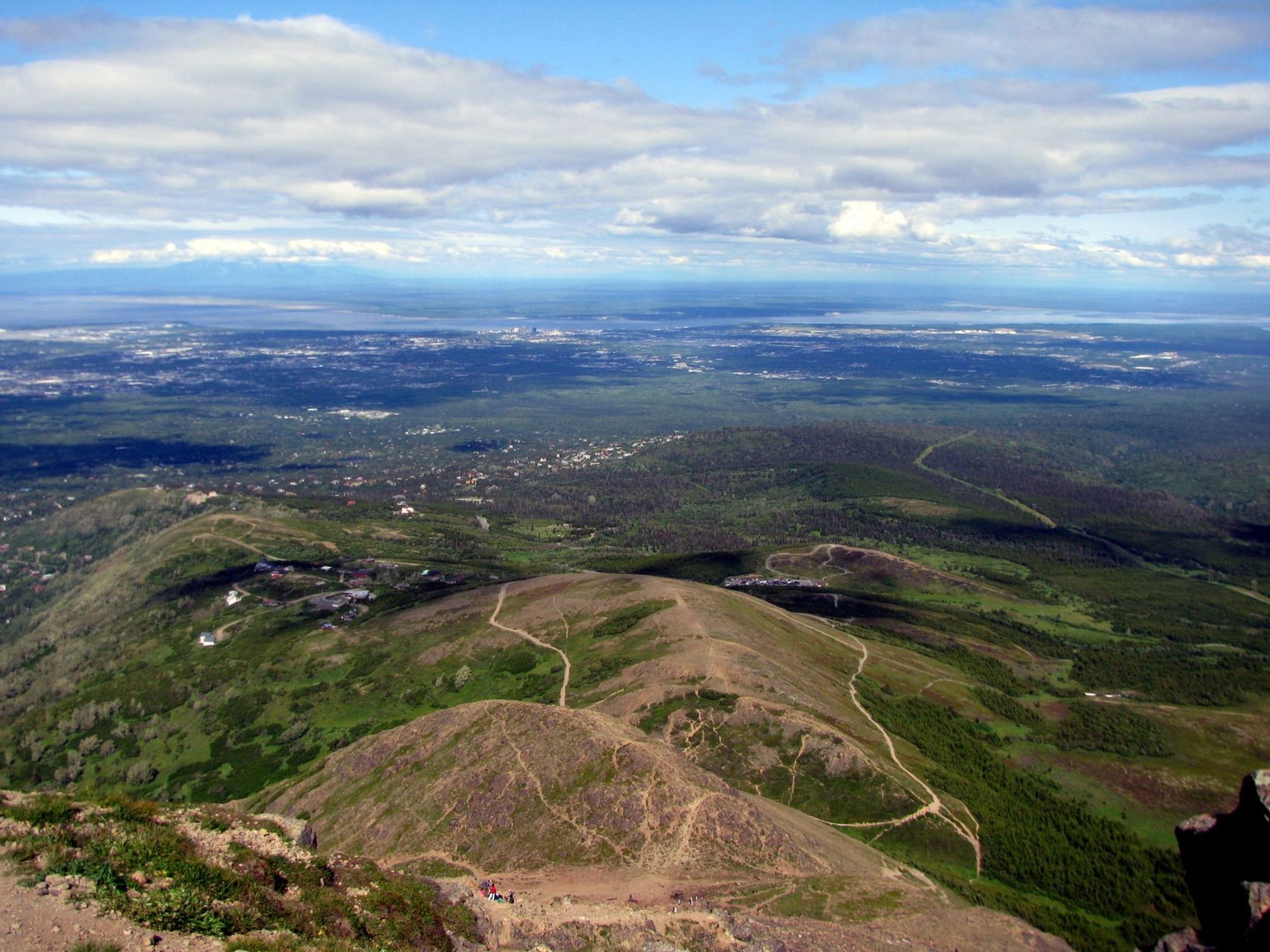 A panoramic view of a mountainous landscape with winding roads and scattered buildings.