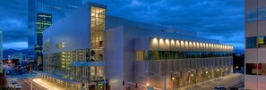 A modern building with large glass windows and a prominent curved glass facade. - Ingra House Hotel (Anchorage)