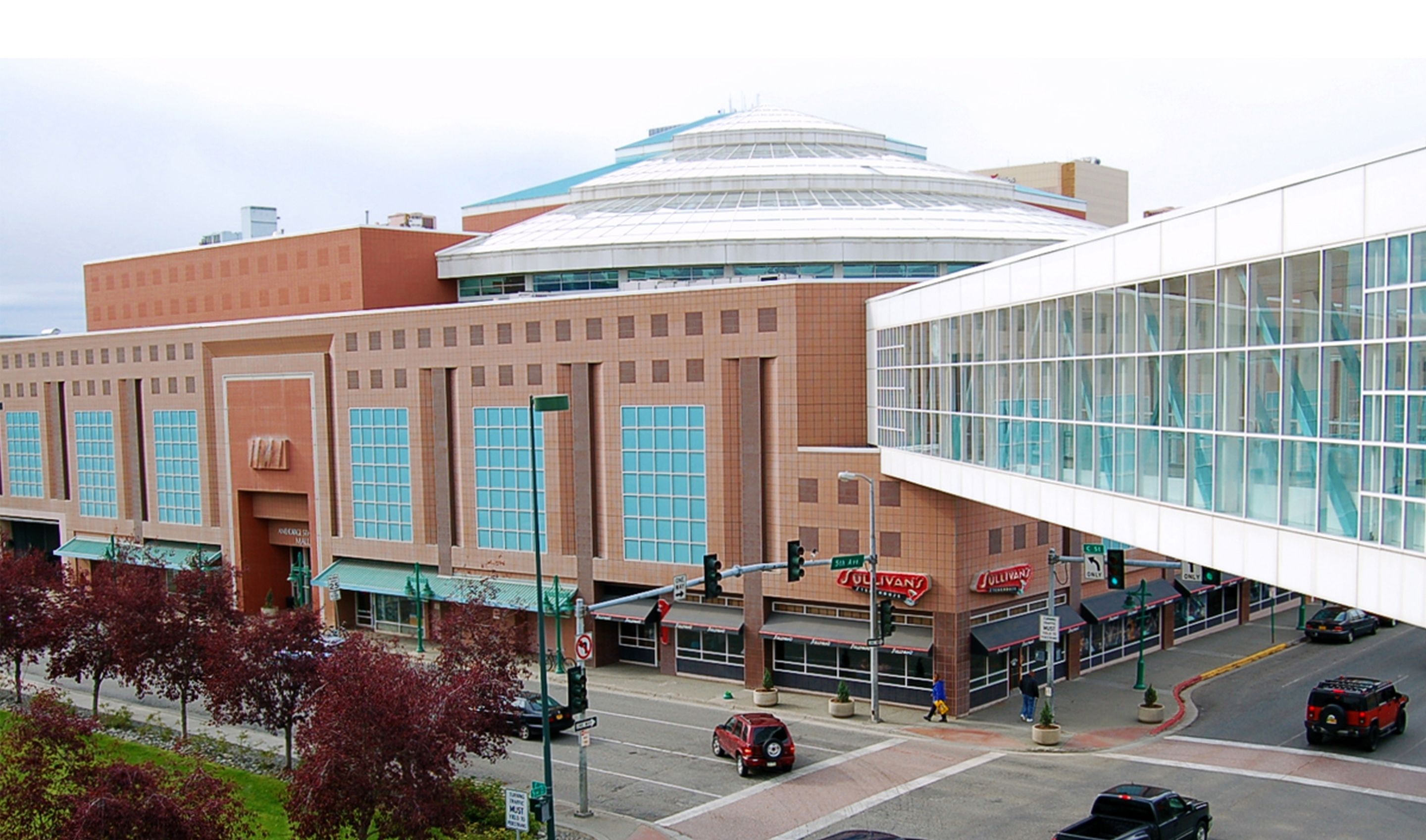 A large building with a distinctive dome and a modern glass extension.
