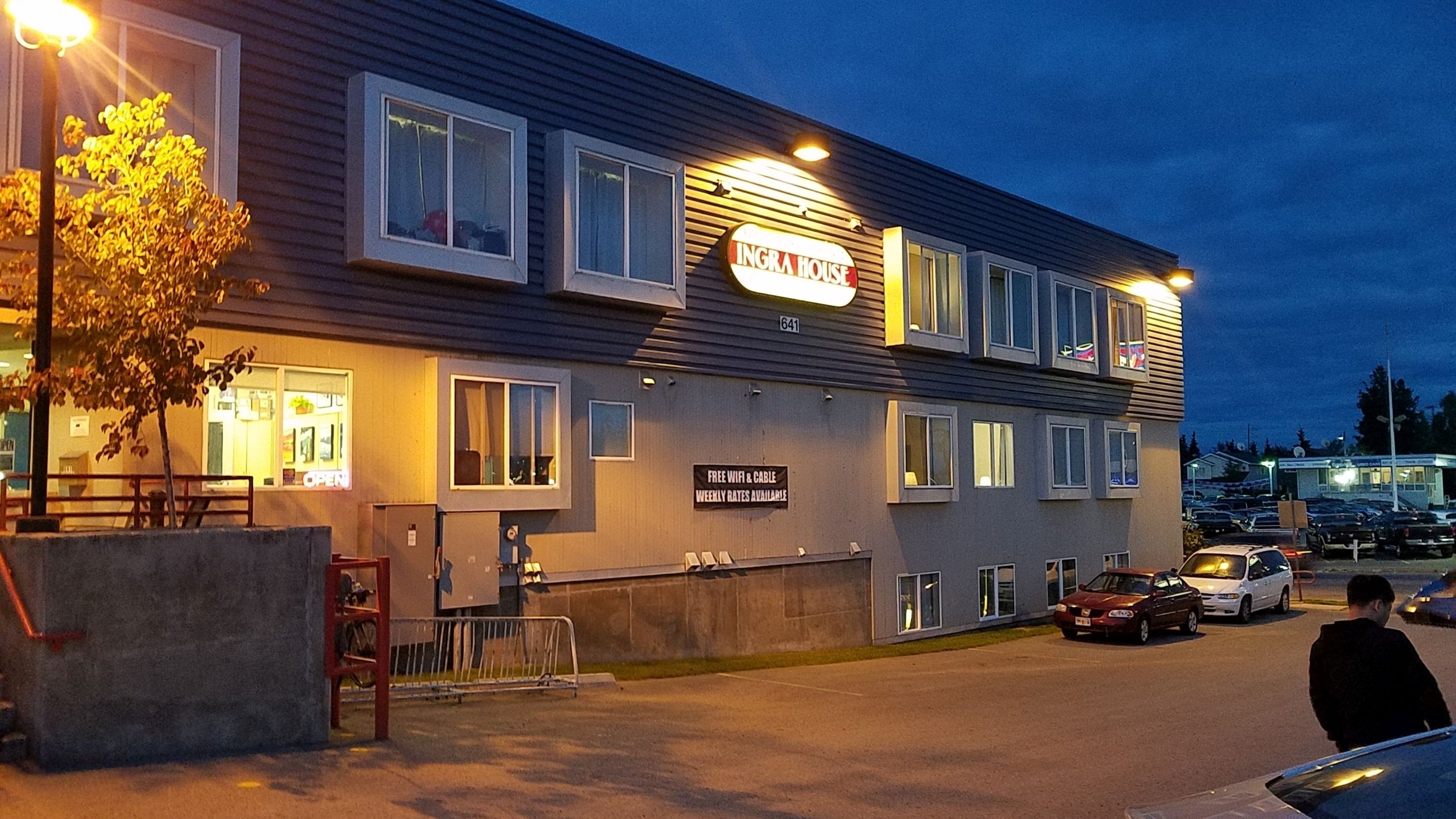 A building with a sign reading "INGRA HOUSE" and a sign offering free WiFi and cable with weekly rates available.
