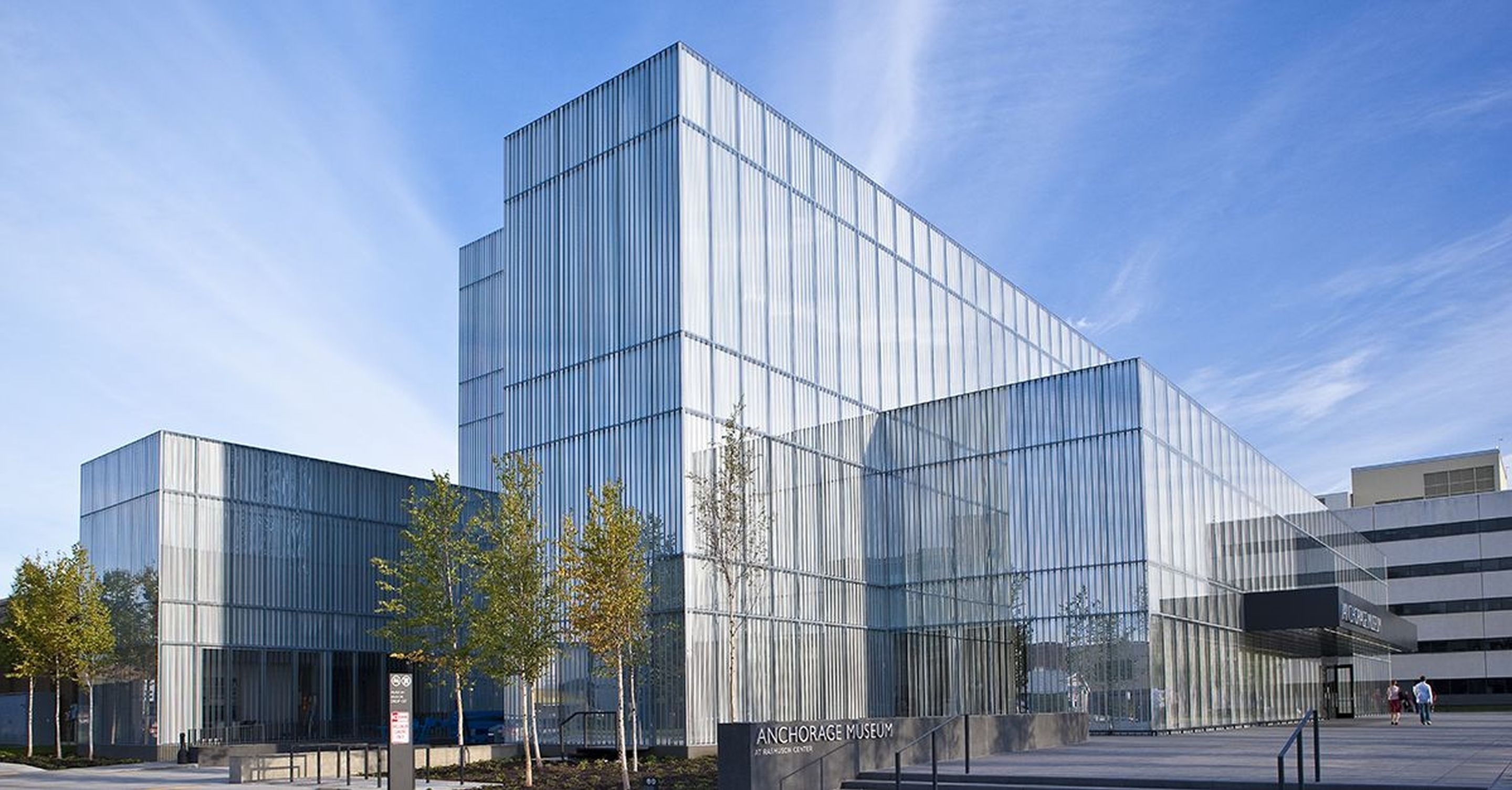 A modern glass building with a flat roof and a symmetrical facade.