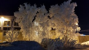 A building with a snow-covered exterior and a lit window.