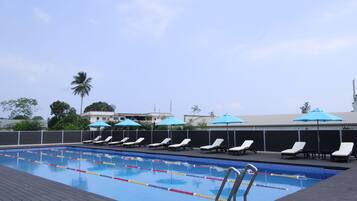 Relax by the pool surrounded by lounge chairs and umbrellas.