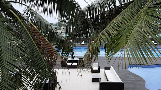 Uma área ao lado da piscina com espreguiçadeiras e piscina.