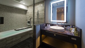 A modern bathroom with a glass-enclosed shower, a marble-tiled wall, a white sink, and a mirror with built-in lighting. - Hotel Times - Adults Only (Tokyo)