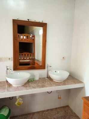 A bathroom with two white sinks, a wooden-framed mirror, and a green chair. - Sea Hua Ha Ha - Hostel (Tulamben)