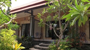 A traditional house with a tiled roof, a stone staircase leading to the entrance, and lush greenery surrounding the property. - Sea Hua Ha Ha - Hostel (Tulamben)