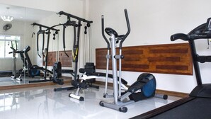 Un gimnasio con diversos equipos de ejercicio, como cintas de correr, elípticas y máquinas de pesas.