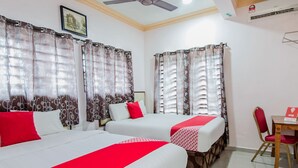 A hotel room with two beds, a ceiling fan, an air conditioning unit, and a small table with a chair. - Hotel SMC Alam Avenue (Shah Alam)