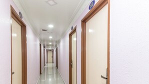 A long, narrow hallway with doors on both sides, each marked with a number. - Hotel SMC Alam Avenue (Shah Alam)