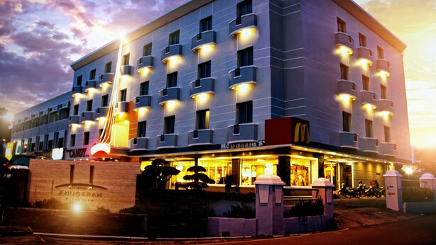 A multi-story hotel with a modern design, featuring balconies and a prominent entrance with a sign. - Hotel Anugerah Palembang (Palembang)