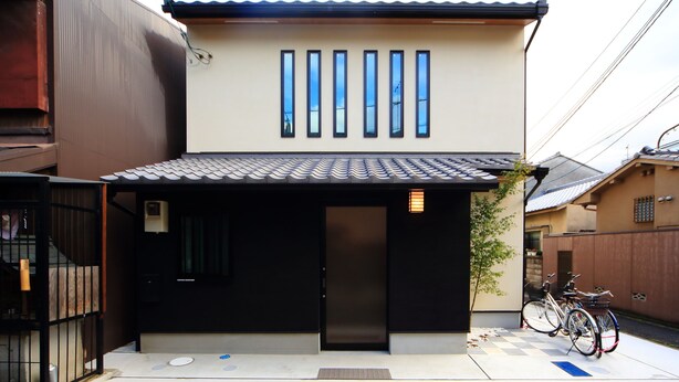 A modern building with a black door, a tiled roof, and a row of windows. - COTO Kyoto Toji 2 (Kyoto)