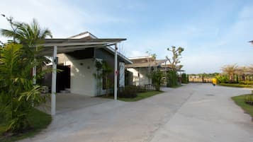 A residential area with houses, a covered driveway, and greenery.