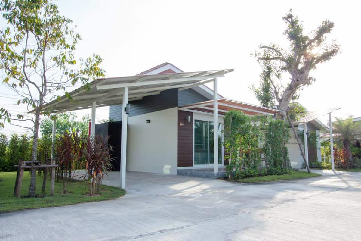 Uma casa moderna com varanda coberta, garagem e gramado bem cuidado.