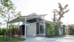 Una casa moderna con porche cubierto, garaje y césped bien cuidado.