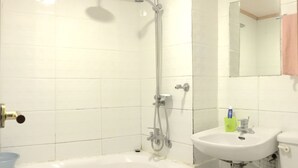 Un ba ño con bañera, ducha y lavamanos.