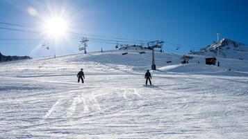 A snowy ski slope with ski lifts and a small cabin.