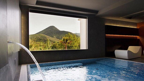 A modern indoor pool with a clear view of a mountain landscape through a large window. - Tenuta Esdra (Pontecorvo)