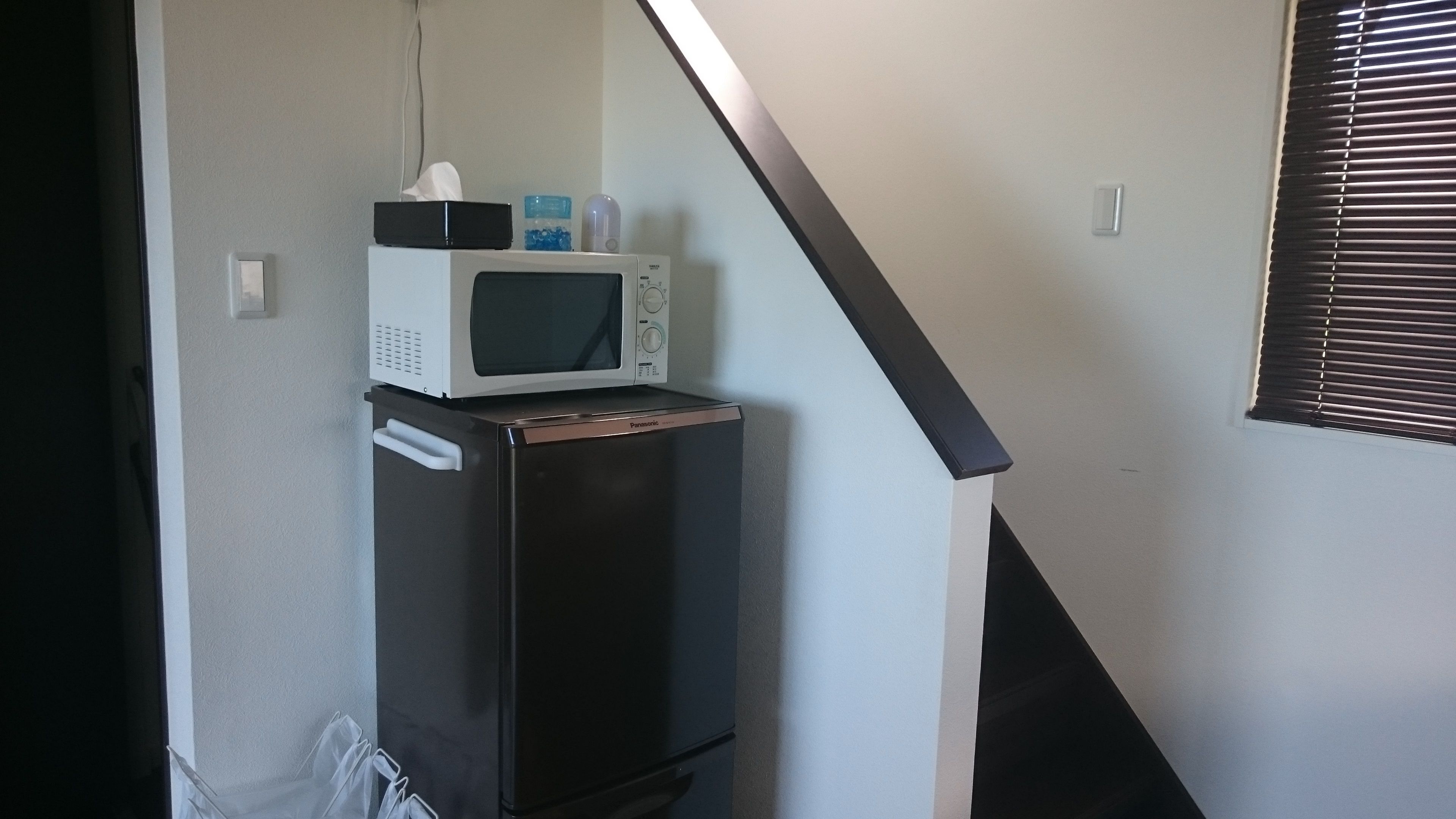 A compact kitchenette with a microwave and a small refrigerator.